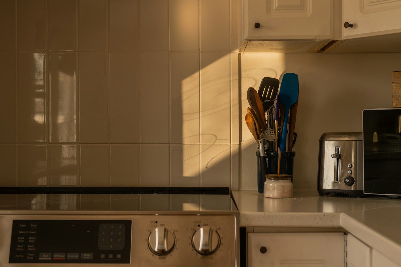 Alat masak listrik dan toaster di meja dapur mungil saat matahari terbenam